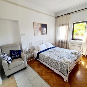 ein Schlafzimmer mit einem Bett und einem Stuhl in der Unterkunft Apartments Ada in Rovinj