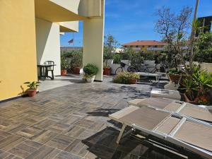 a patio with chaise lounges and tables at Casa Giagoni in Santa Teresa Gallura