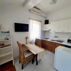 eine Küche mit einem Holztisch und Stühlen im Zimmer in der Unterkunft Apartments Ada in Rovinj
