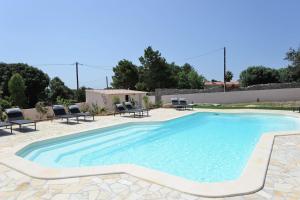 a swimming pool in a backyard with chairs around it at Résidence Canava in Bonifacio