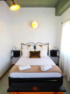 een slaapkamer met een bed met twee handdoeken erop bij Axilleion Guest House in Ermoupoli