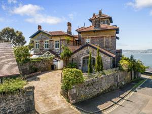 ein altes Haus mit einer Steinmauer in der Unterkunft Vane Tower - Award winning designer retreat with panoramic sea views in Torquay