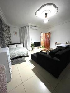 uma sala de estar com uma cama e um sofá em Cheb's House em Abidjan