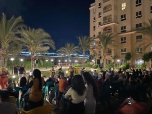 a crowd of people sitting in front of a building at 5 stars Studio Aqua View North coast in Borg El Arab