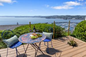 einen Tisch mit einer Schale Obst und einer Flasche Wein in der Unterkunft Vane Tower - Award winning designer retreat with panoramic sea views in Torquay