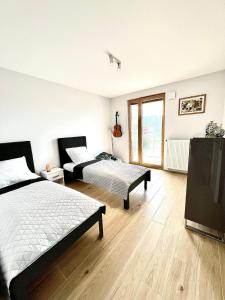 1 dormitorio con 2 camas y TV. en Mimosa Kraków Apartment en Cracovia