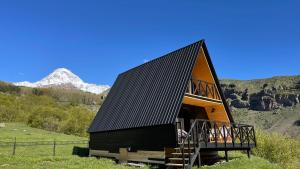 un grande edificio con tetto nero e scala di view a Kazbegi