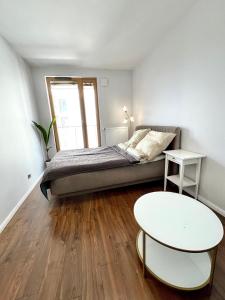 1 dormitorio con 1 cama y 2 mesas en Mimosa Kraków Apartment en Cracovia