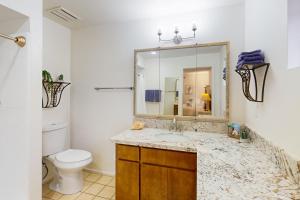 une salle de bain avec un lavabo, des toilettes et un miroir dans l'établissement On the 13th Hole, à Leisure World 16 autres photos