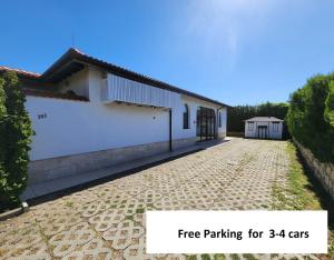 a white building with a parking for cars at Private Villa First line with sea view in BlackSeaRama Golf A PLUS LOCATION PRIVACY POOL in Balchik