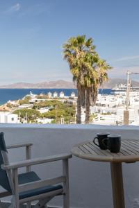 einen Tisch mit zwei Kaffeetassen auf dem Balkon in der Unterkunft Dimele in Mykonos Stadt