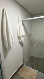 Una ducha con puerta de cristal y una toalla en la pared. en Diamond Flats 305 - São Lourenço, en São Lourenço