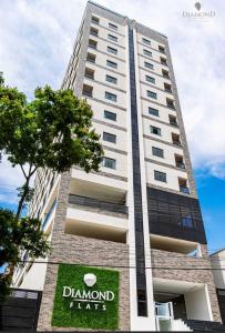 Un edificio alto con un cartel delante. en Diamond Flats 305 - São Lourenço, en São Lourenço