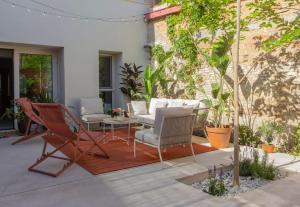 a patio with chairs and a table and some plants at La Casa del Mar in Valencia