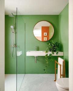 a green bathroom with a sink and a mirror at La Casa del Mar in Valencia