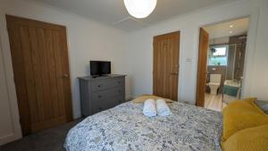 a bedroom with a bed with two white shoes on it at Chy Lowen Private rooms with kitchen, dining room and garden access close to Eden Project & beaches in Saint Blazey