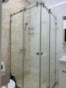 La salle de bains est pourvue d'une douche avec une porte en verre. dans l'établissement Айкол, à Bokonbayevo