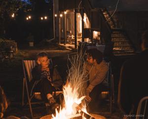 Ein paar Leute sitzen um ein Feuer herum in der Unterkunft Wietorówka in Lubomierz