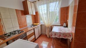 a small kitchen with a table and a window at Apartament Gabriela in Mangalia