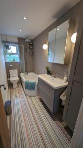 y baño con bañera, lavabo y aseo. en Chy Lowen Private rooms with kitchen, dining room and garden access close to Eden Project & beaches, en Saint Blazey