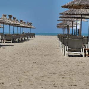 a row of chairs and umbrellas on a beach at ILSA Apartment in Durrës