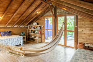 a hammock in a room in a log cabin at Hotel Playa Manglares Isla Baru in Barú