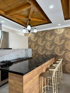a kitchen with a counter and bar stools at Айкол in Bokonbayevo