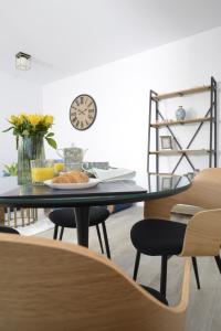 a dining room with a glass table and chairs at The CLOCK in Voluntari