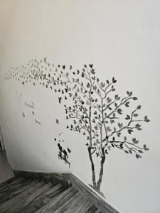 un árbol con hojas y pájaros en una pared en Graceland rooms and suites en Capo Vaticano