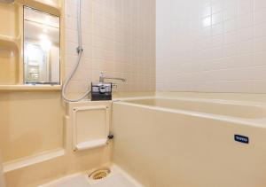 a bathroom with a bath tub and a sink at APA Hotel Kanazawa Katamachi EXCELLENT in Kanazawa