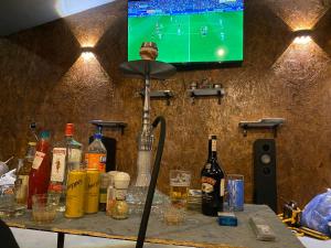 stolik z butelkami alkoholu i telewizor na ścianie w obiekcie Family Hotel Sunset w mieście Czakwi