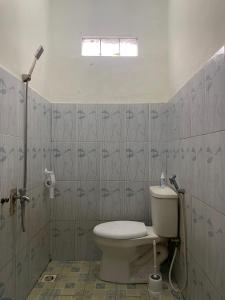łazienka z toaletą i prysznicem w obiekcie V & E Home Stay Cimaja Beach w mieście Cimaja