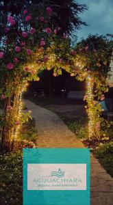 an arch with lights and a sign in a garden at ACQUACHIARA ISEO CENTER BED AND BREAKFAST villa with PARKING inside Foresteria in Iseo