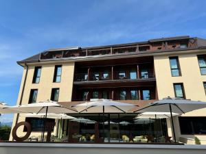 un edificio con tavoli e ombrelloni di fronte ad esso di Ile Hotel a Peschiera del Garda
