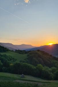 einen Sonnenuntergang über den Hügeln in den rauchigen Bergen in der Unterkunft Kuća za odmor Andrea in Bajina Bašta