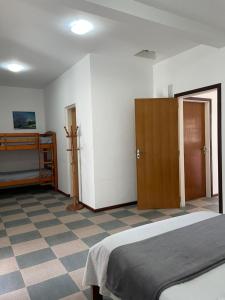 um quarto com uma cama e piso em azulejo em Suíte Família para até 4 pessoas em casa de praia em Bertioga