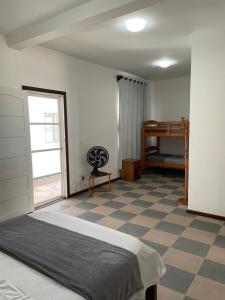 um quarto com uma cama e um piso em xadrez em Suíte Família para até 4 pessoas em casa de praia em Bertioga