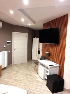 Zimmer mit einem Schreibtisch und einem TV an der Wand in der Unterkunft B&B Berlen in Torre Maggiore