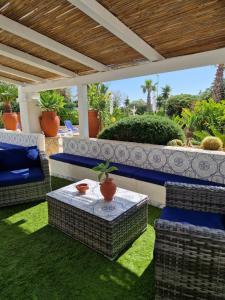 patio con sedie in vimini e tavolo sull'erba di Angolo di Paradiso a Favignana