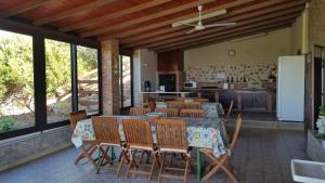 een patio met een tafel en stoelen en een keuken bij Bed House Floristella in Valguarnera Caropepe