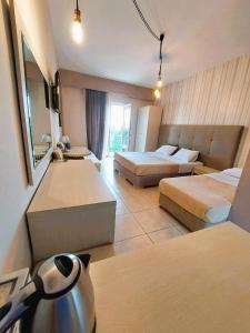 a hotel room with two beds and a television at Villa Nickolas in Paleo Tsifliki