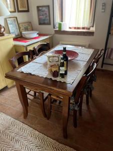 una mesa de madera con dos botellas de vino. en Agriturismo Campo dei Lupi en Vicopisano