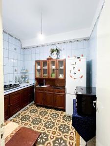 a kitchen with a refrigerator and a tile floor at Entire House with private Rooftop in Al Hoceïma
