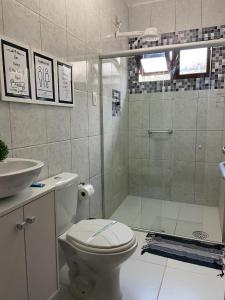 a bathroom with a shower and a toilet and a sink at Pousada Maré Alta in Maceió