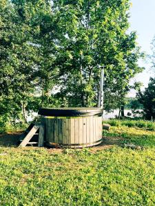 una bañera de madera en medio de un campo en Brīvdienu māja Dinary en Dagda