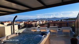 a hot tub on a balcony with a view of a city at Apartment Bruno - Luxury Penthouse with Jacuzzi in Zadar