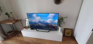 uma televisão de ecrã plano numa bancada branca num quarto em Erli's Apartment em Golem