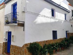a white building with blue windows and a balcony at Casa Picasso in Ítrabo
