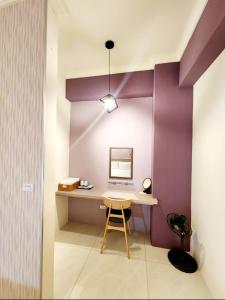 台東市的住宿－別有洞天包棟電梯民宿，紫色墙壁的客房内的一张书桌