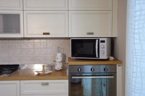 una cucina con forno a microonde e piano cottura di RITA LITTLE HOUSE a Mascali
